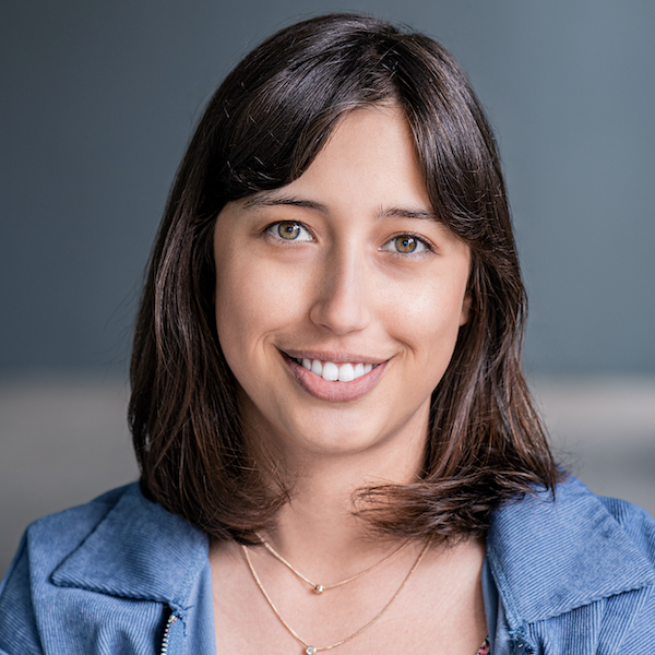 Monica Cecilia Lucas smiling headshot wearing a denim colored jacket