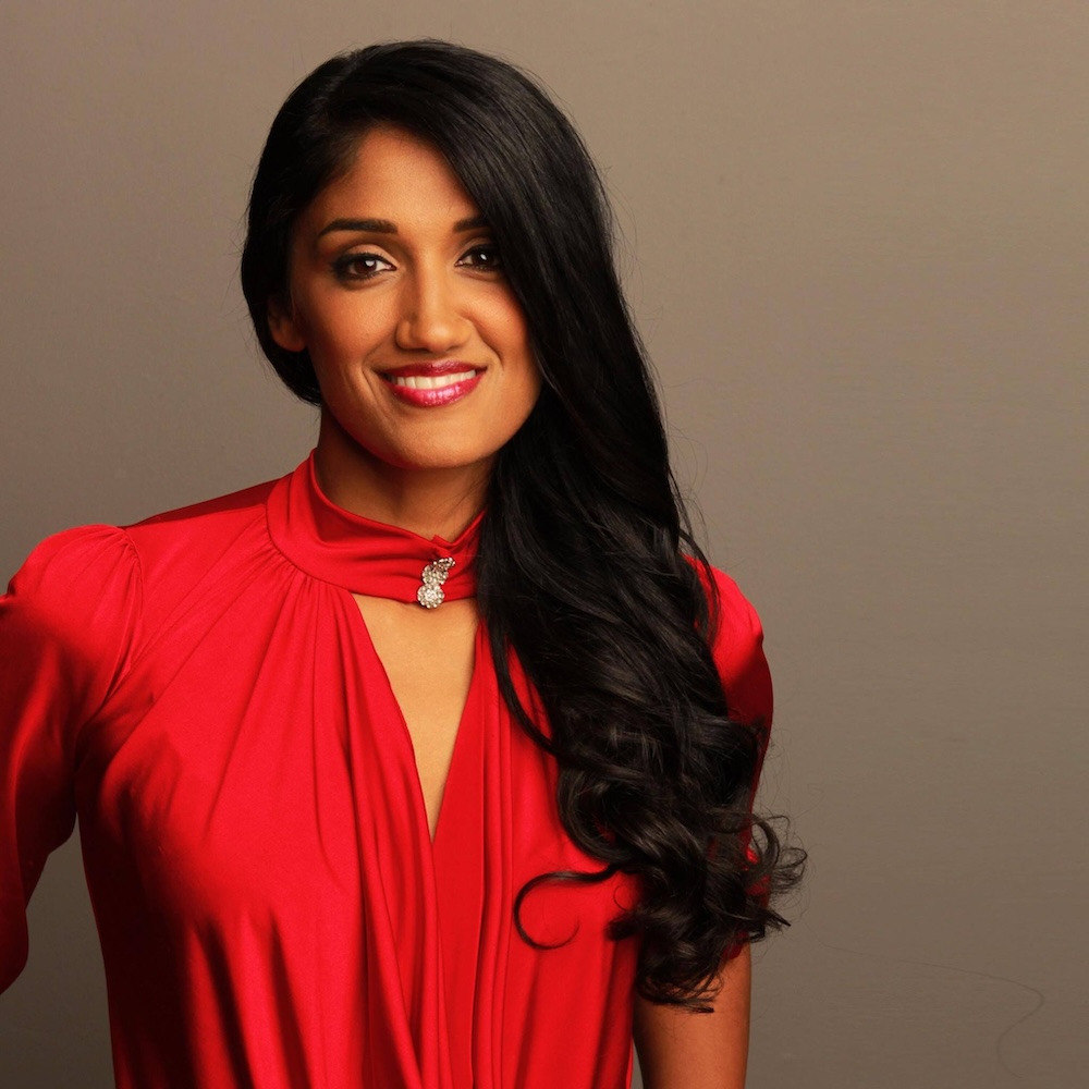 Radha Mehta smiling wearing a red dress