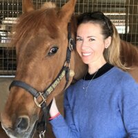 Sabrina Mansfield smiling with a horse next to her