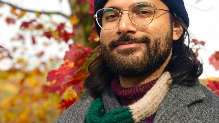 Saleem Nasir Gondal smiling headshot wearing a hat in front of a tree in the fall