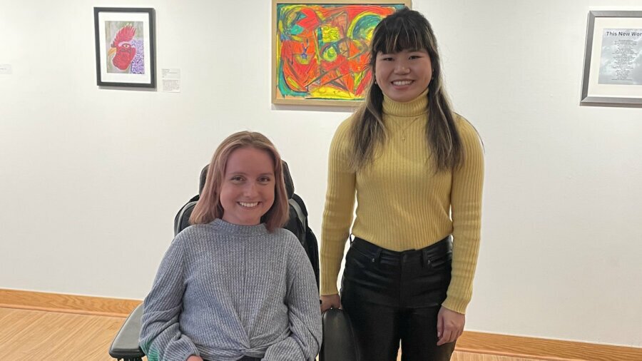 Jessica Hetzel and Ava Rigelhaupt smile together in an art gallery at the JCC in Detroit
