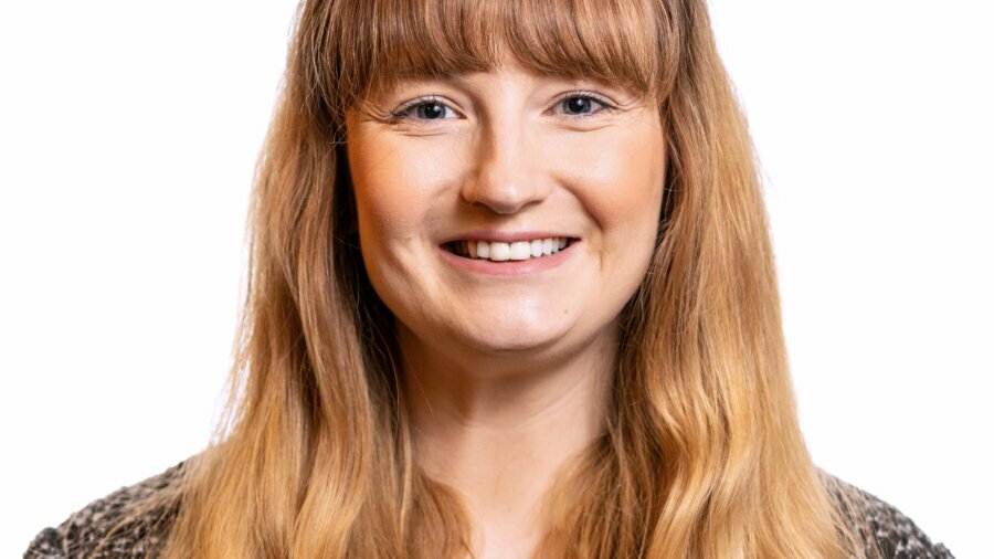 Julie Schurman smiling headshot wearing a black sweater and a white shirt