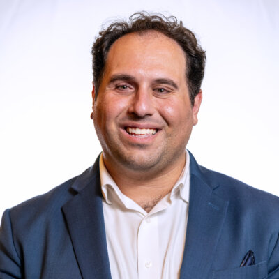 Rostom Dadian smiling headshot wearing a navy blue blazer
