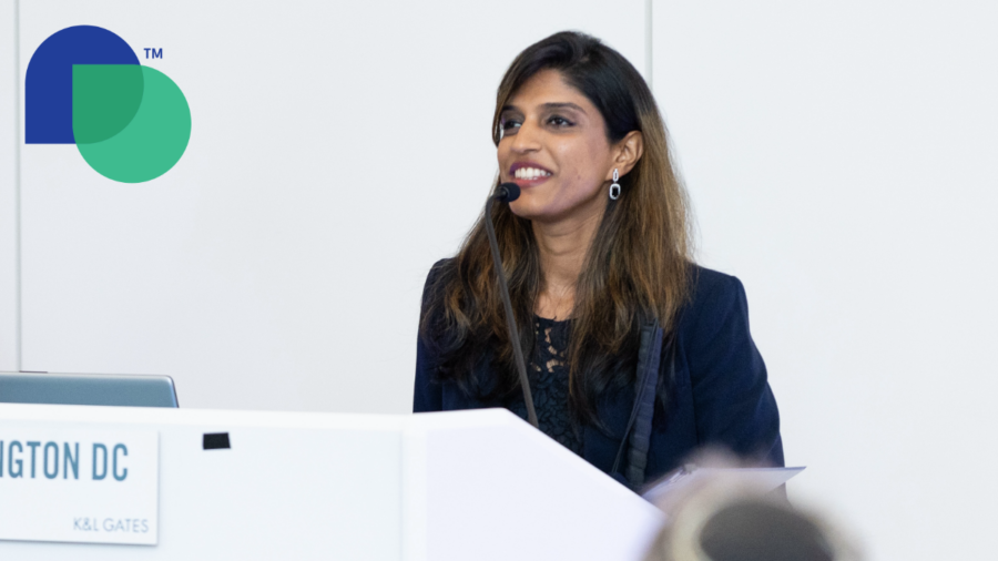 Khadija Bari smiling while speaking behind a podium at Disability Belongs' Disability Impact Awards in July 2024. Disability Belongs trademarked logo with green and blue overlapping droplet shapes in upper left.