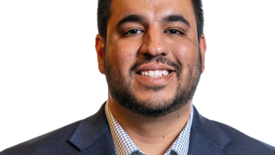 Franklin Anderson smiling headshot wearing a navy blue blazer and a blue and white checkerboard dress shirt