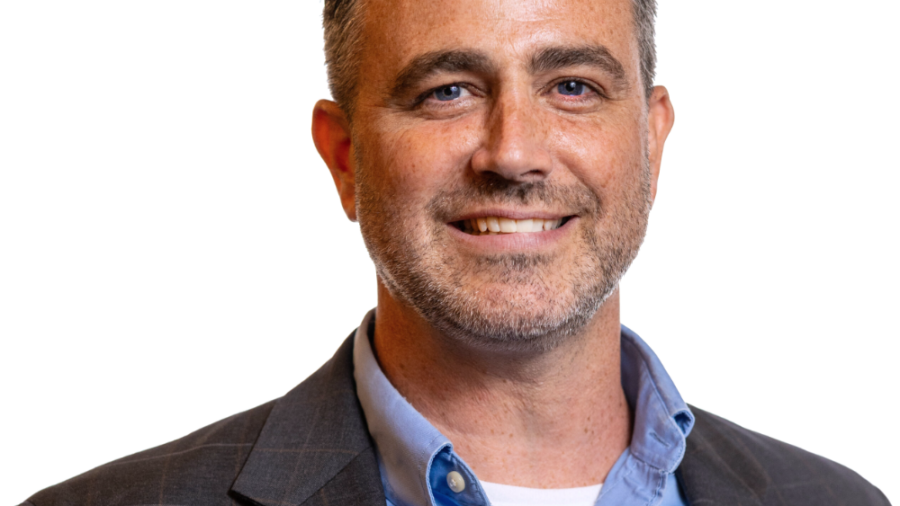 Kevin McCloskey smiling headshot wearing a grey blazer and blue dress shirt