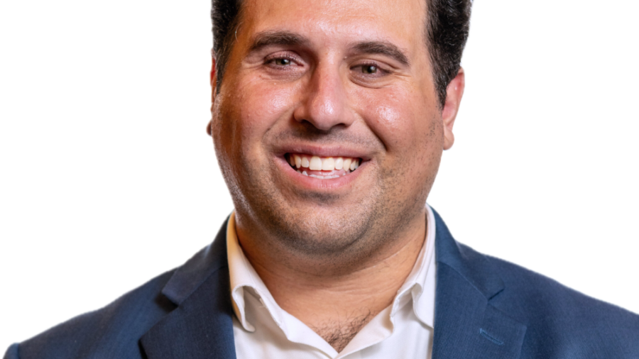 Rostom Dadian smiling headshot wearing a navy blue blazer