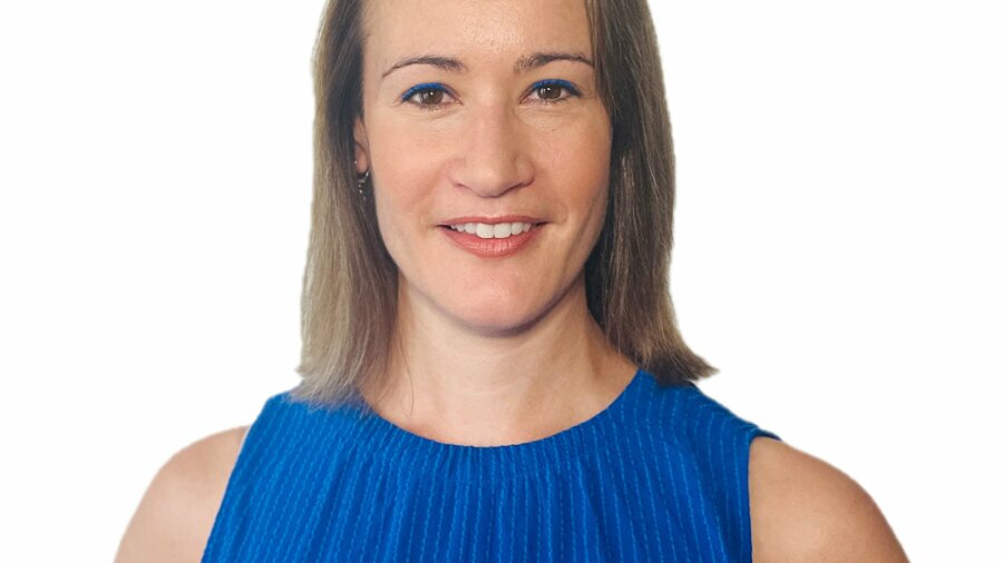 Sarah Coble smiling headshot wearing a blue sleeveless dress