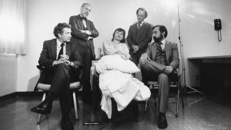 still from Sundance Film Life After showing a disabled woman surrounded by men in suits