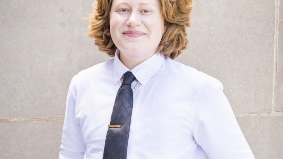 E Murphy King smiling headshot wearing a white dress shirt and black tie