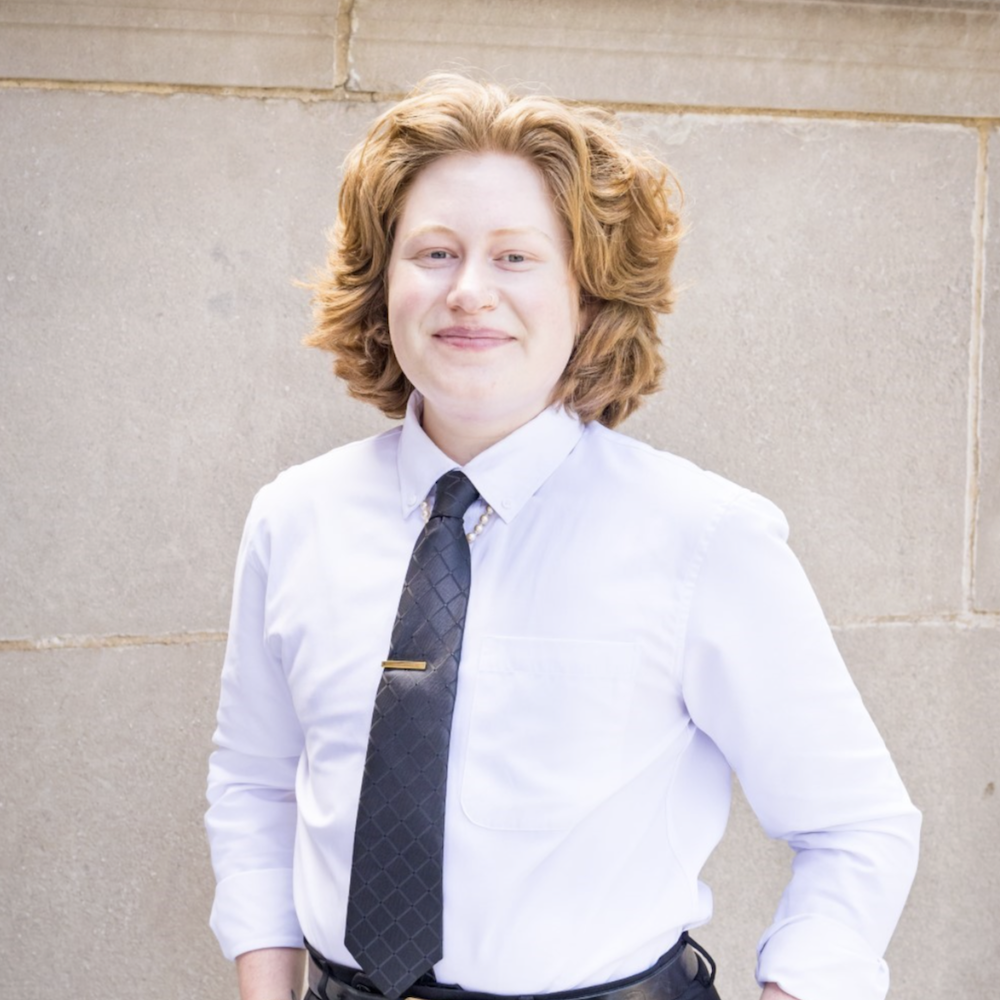 E Murphy King smiling headshot wearing a white dress shirt and black tie