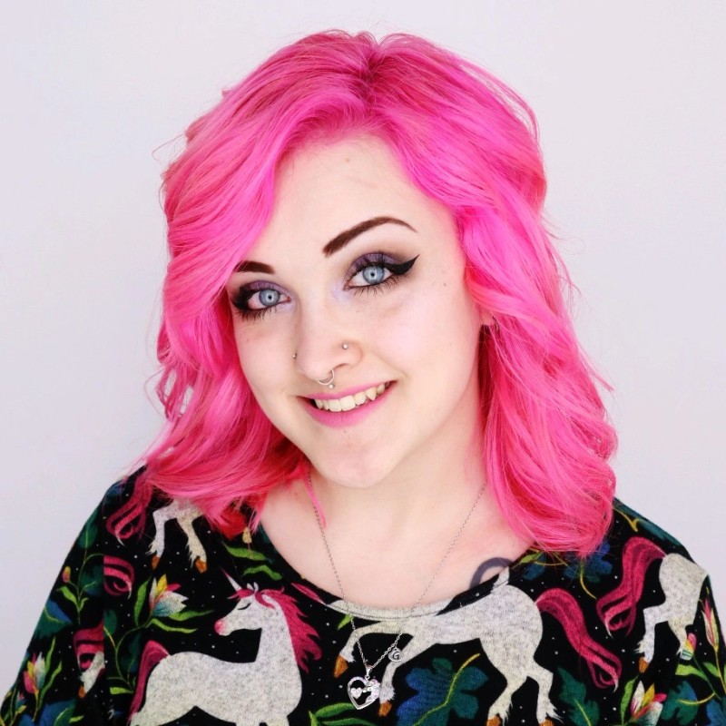Gwen Cotten smiling headshot wearing a shirt with mythical animals on it