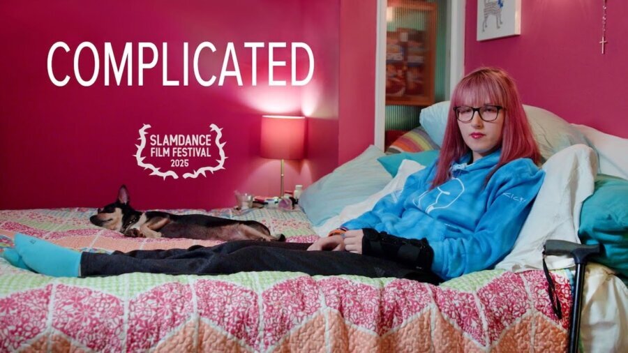 Complicated film poster art with a woman with EDS sitting on a bed in a room with pink walls. icon for Slamdance Film Festival 2025