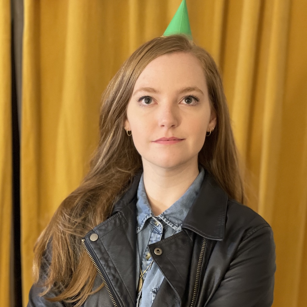 Alex Cottle headshot wearing a green party hat