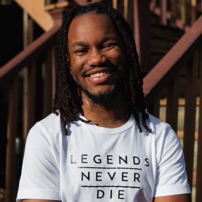 Kawan Glover smiling headshot wearing a t shirt that says Legends Never Die