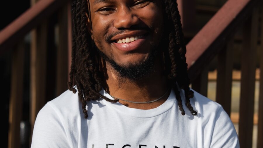 Kawan Glover smiling headshot wearing a t shirt that says Legends Never Die
