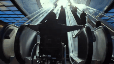 key art for Rising Phoenix with person in a wheelchair at the bottom of an escalator looking up towards the top